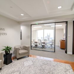 An office with beige leather chairs and a window opening to a conference room. There is an Andrews Myers sign on the wall
