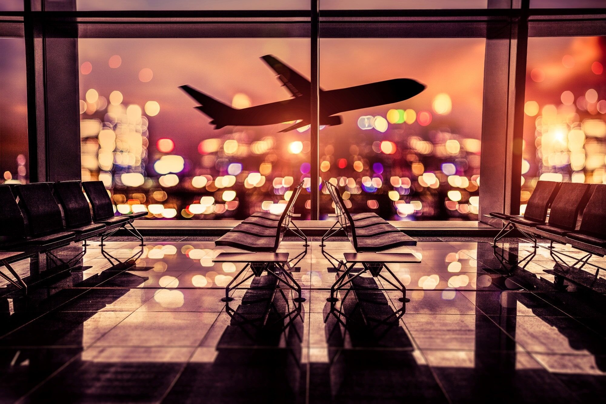 Four rows of seats in front of a window view of a plane taking off