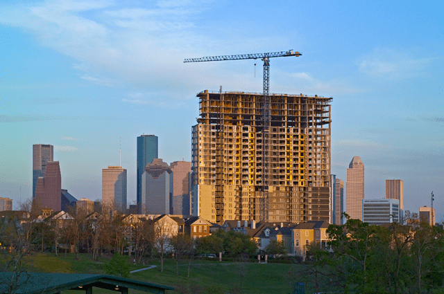 Large skyscraper construction project in front of the Houston skyline