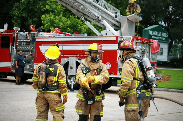 Three firefighters talking in front of a fire truck